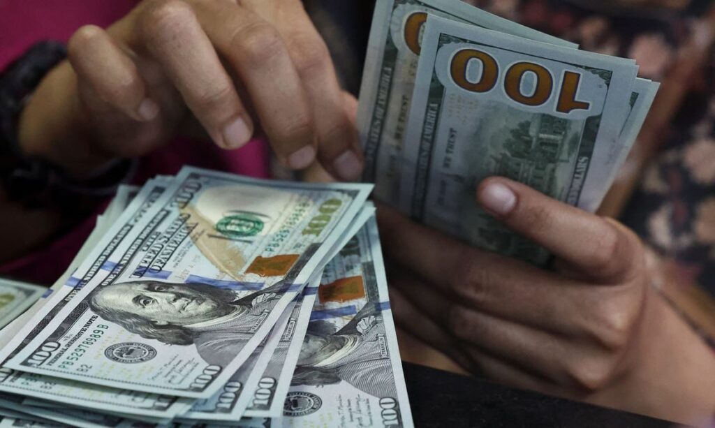Dólar fecha abaixo de R$ 5 e recua 1,58% na semana